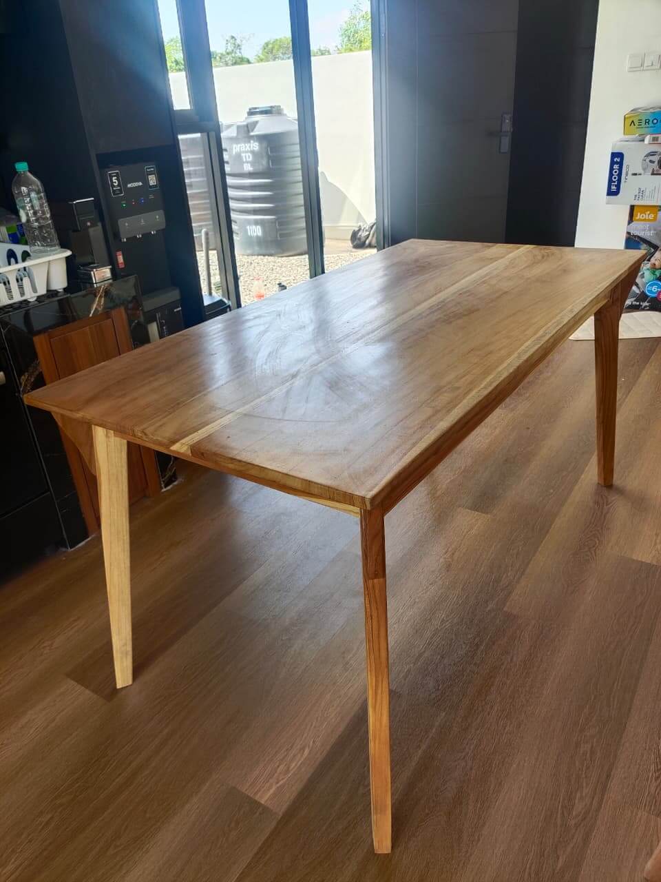 Solid wood dining table with smooth surface and sleek sturdy legs in a modern room setting.