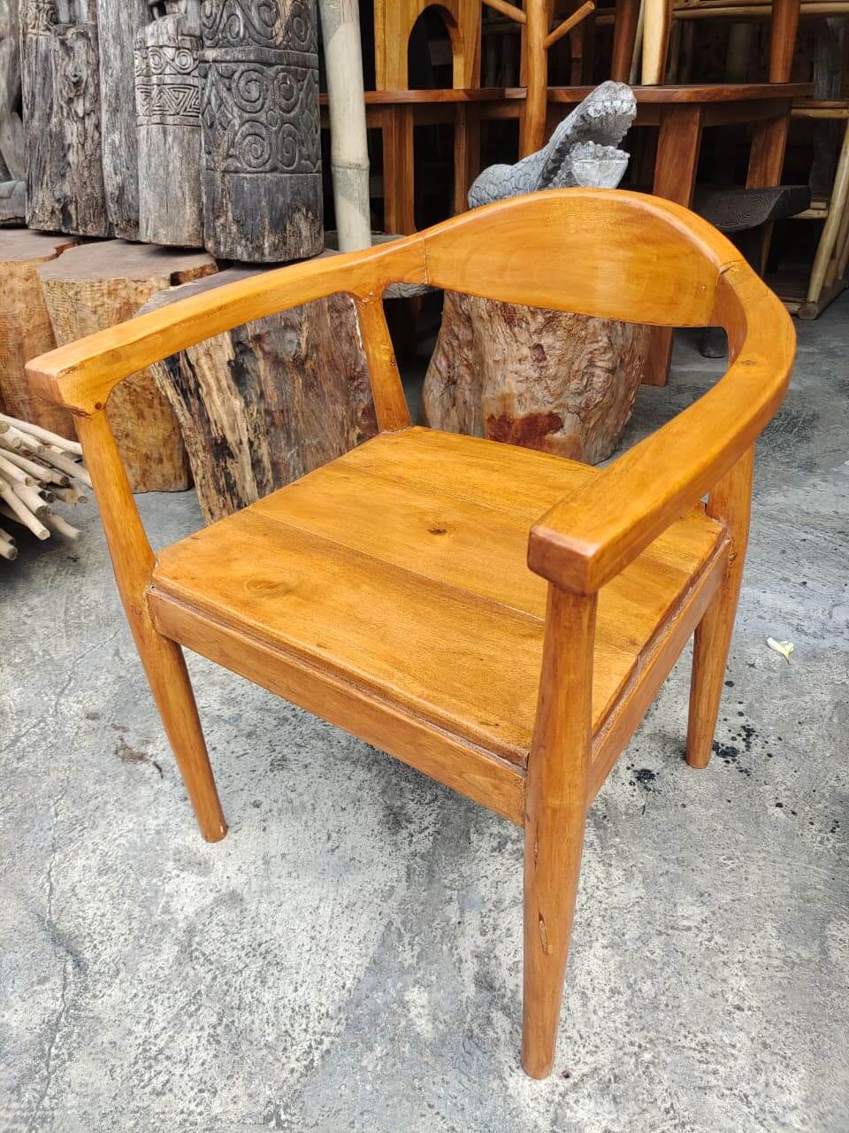 Kursi A kayu solid dengan sandaran melengkung dan finishing natural yang mengkilap.