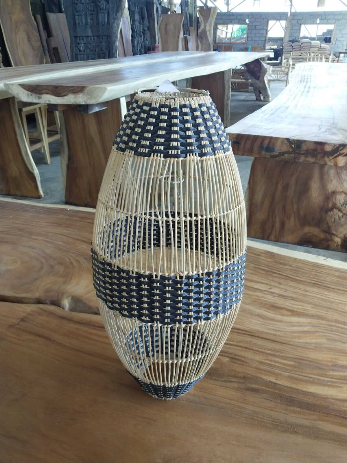 Handmade oval rattan lampshade with beige vertical frame and black and white ribbon