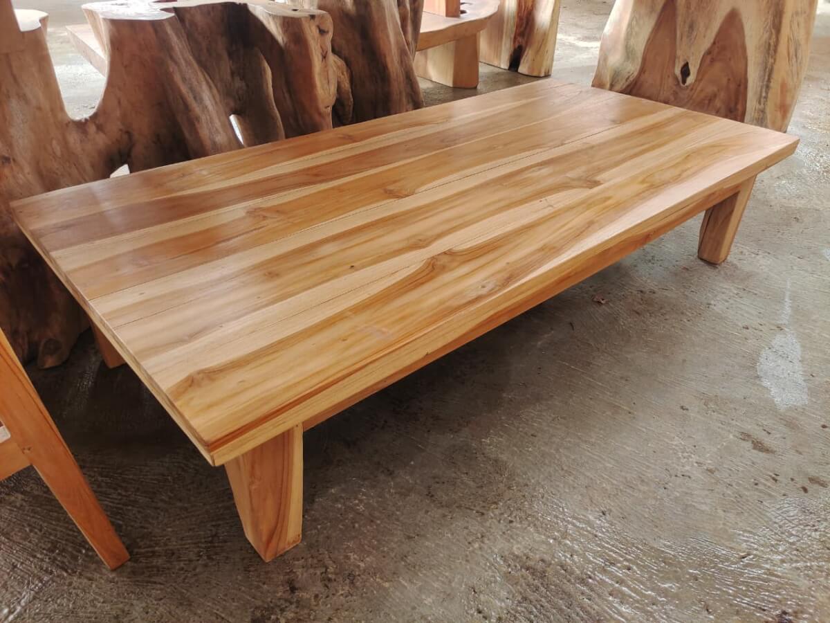 Meja tamu kayu solid masif dengan permukaan lebar dan corak serat kayu alami yang mewah.