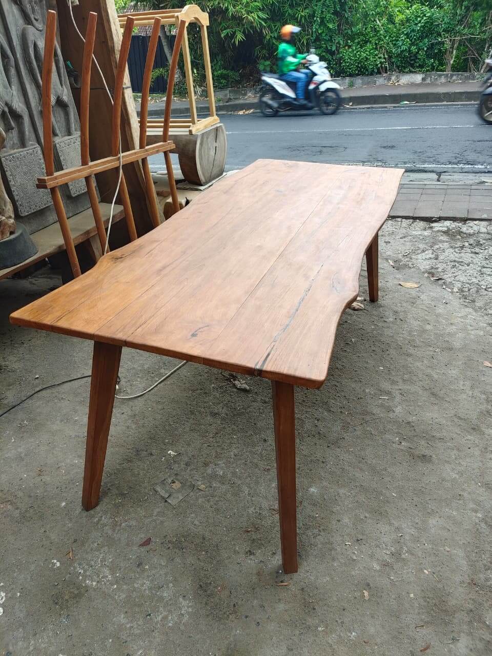 Natural dining table made of solid wood with live edge following the tree's original shape.