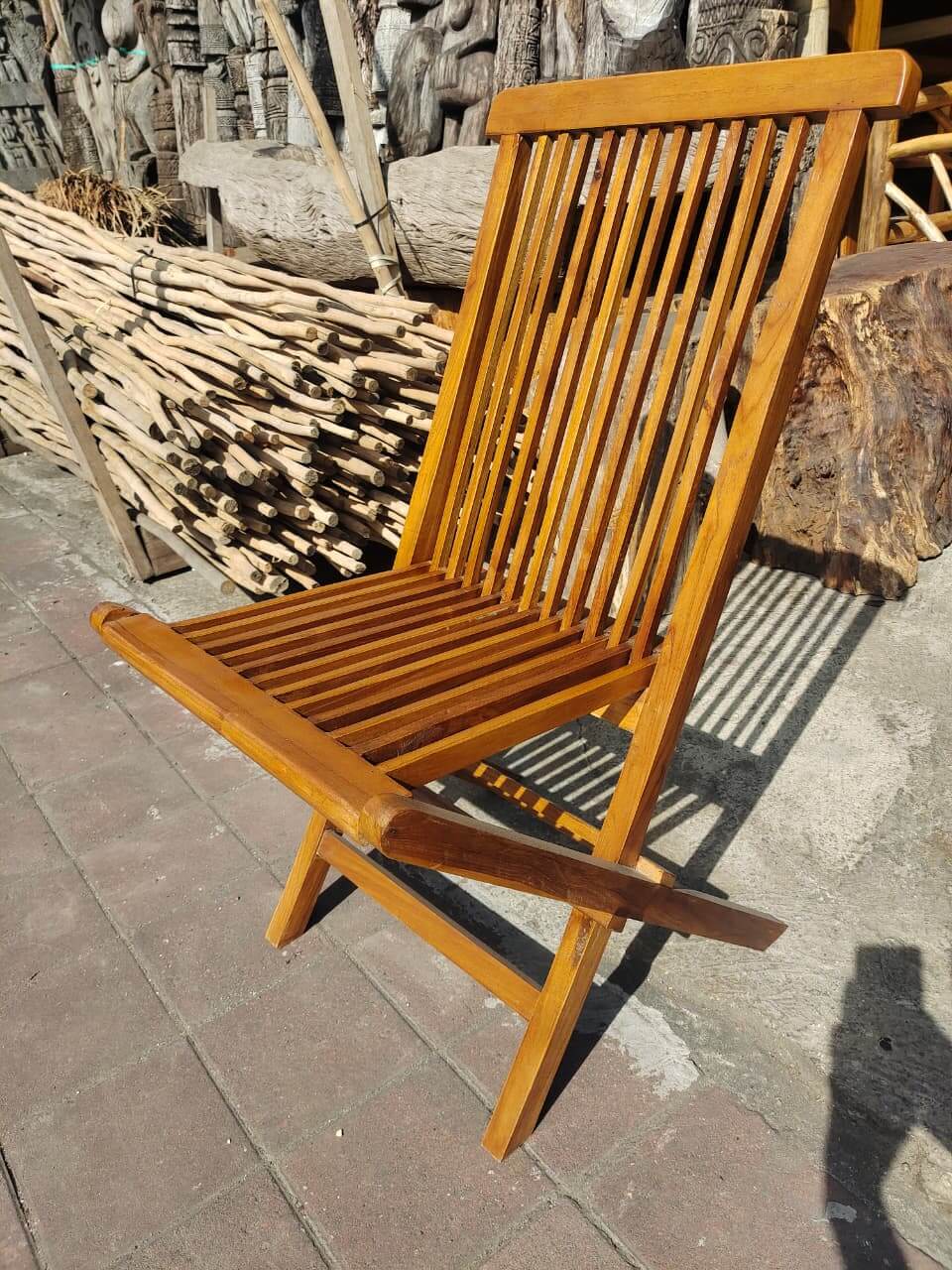 Wooden folding sun lounger with slat design outdoors.