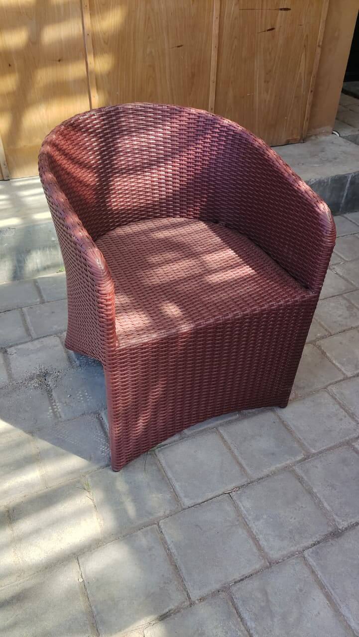 Synthetic rattan chair with curved design and integrated armrests