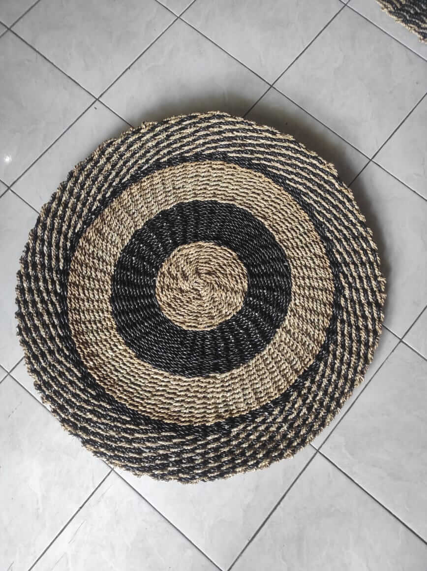 Black and cream spiral pattern round carpet made from woven natural jute fibers